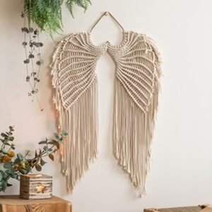Angel wings macrame wall hanging above a neutral bedroom bed