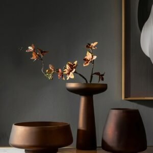 Frosted glass vase with dried flowers on a wooden dining table