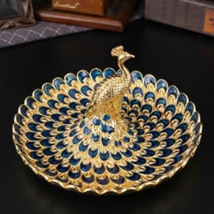 Golden peacock decorative tray on a dining table with fruit